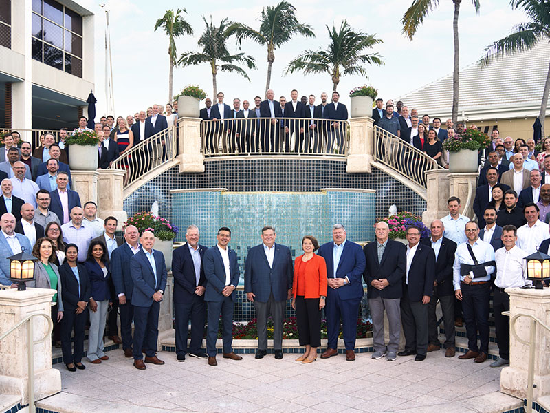 Colleagues gather on steps for a group photo at AMETEK University